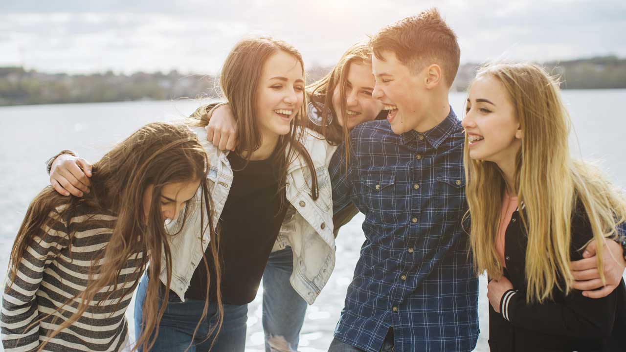Schüler halten ihre Daumen hoch und sitzen auf einem Heuballen im Osnabrücker Land