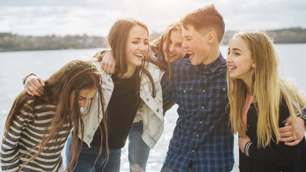 Schüler halten ihre Daumen hoch und sitzen auf einem Heuballen im Osnabrücker Land