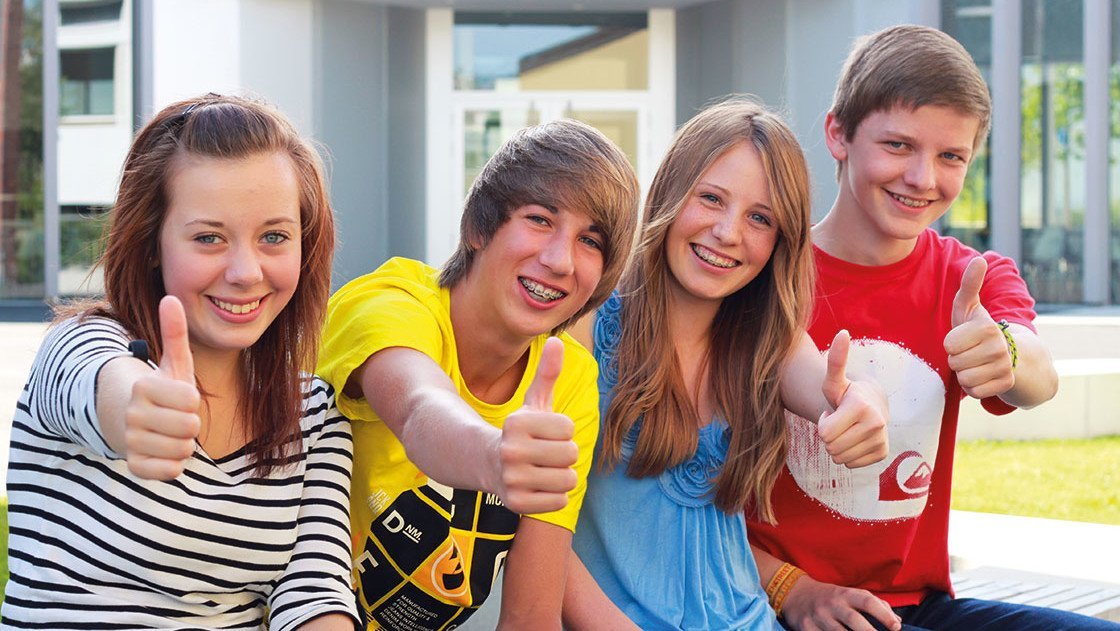 Daumen hoch zur Reisepreisgarantie Junge Leute zeigen den Daumen hoch