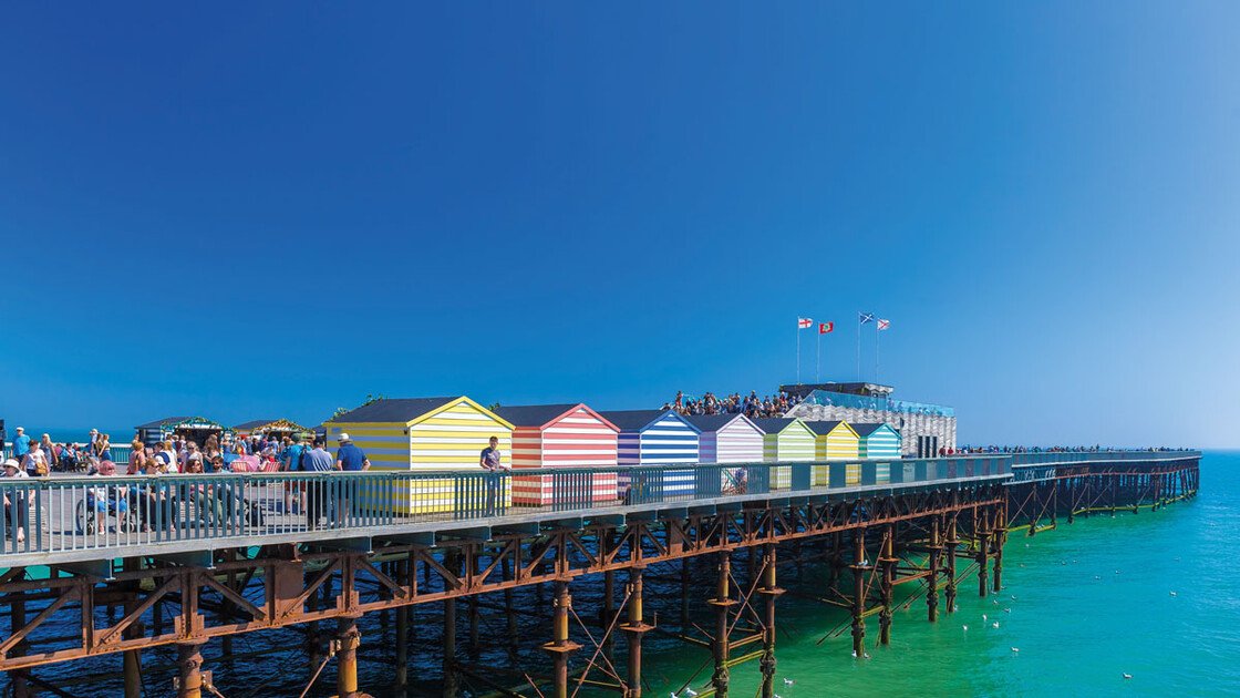 Blick auf den Pier in Hastings mit bunten Strandkabinen