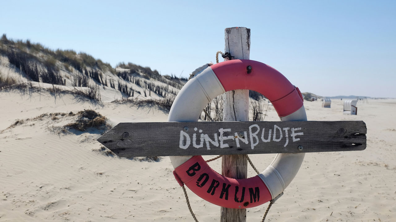 Rettungsring als Wegweiser am Strand von Borkum