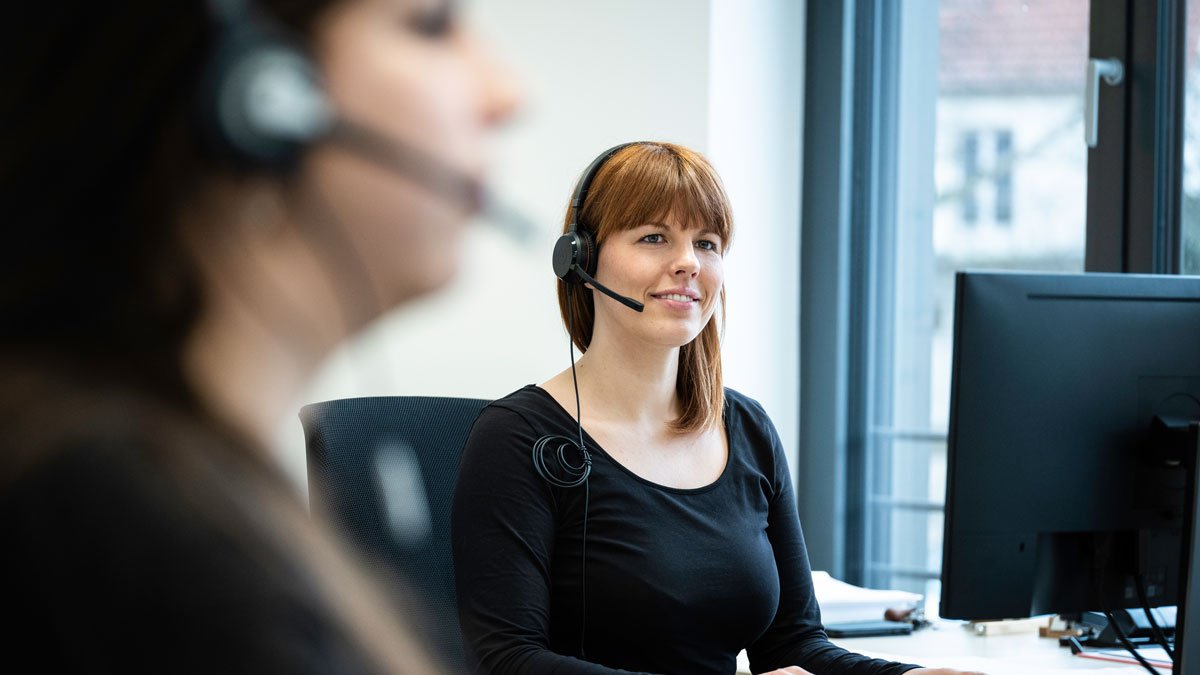 Vorteile bei CTS Reisen Mitarbeiter mit Headset am Arbeitsplatz