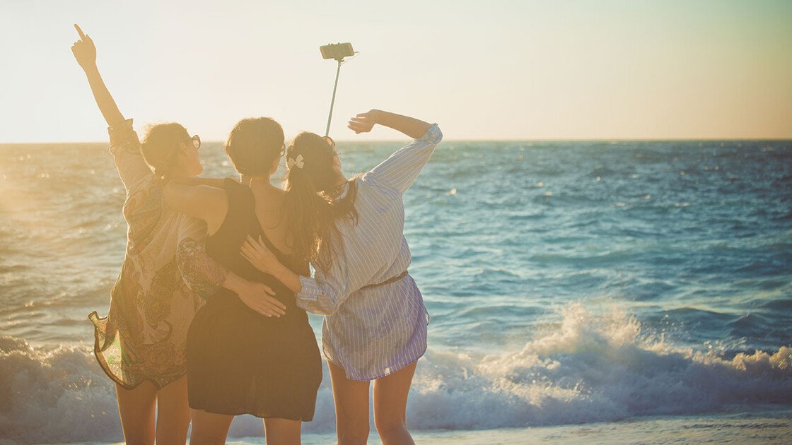 Mädchen machen am Strand ein Selfie