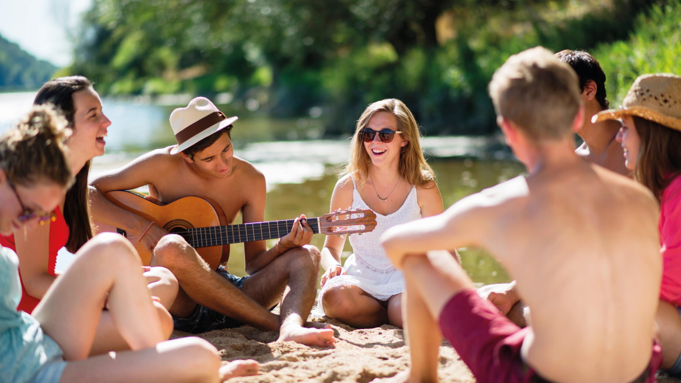 Schüler am See mit Gitarre