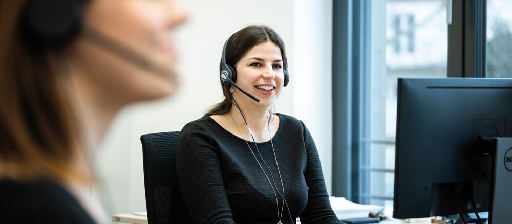 Mitarbeiter mit Headset am Arbeitsplatz