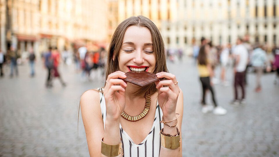 Schülerin isst Schokolade auf einem Platz in Brüssel