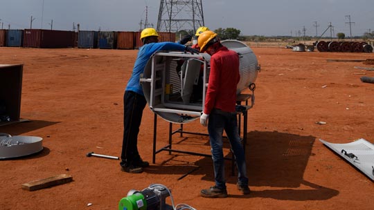 Projektfoto Windenergie Indien Projektfoto für die Windenergie in Indien: Zwei Arbeiter stehen an einem Teil einer Windkraftanlage