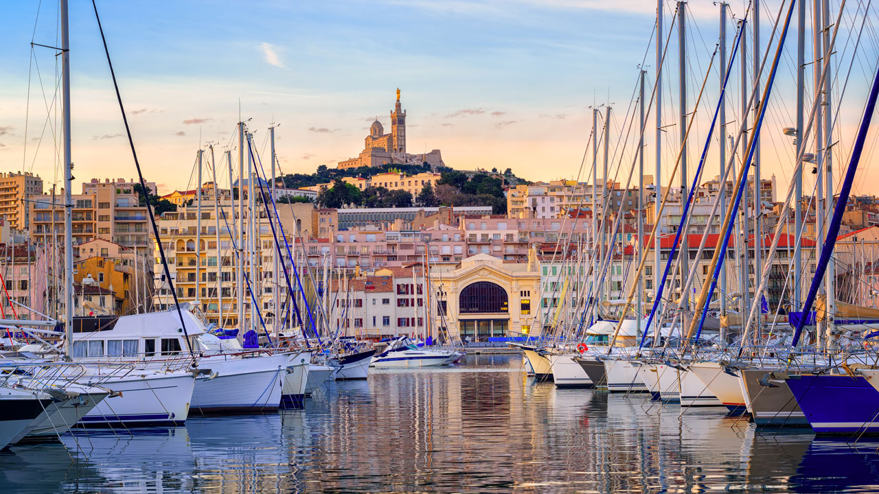 Alter Hafen von Marseille mit vielen Segelbooten und dem Blick auf das Wahrzeichen von Marseille