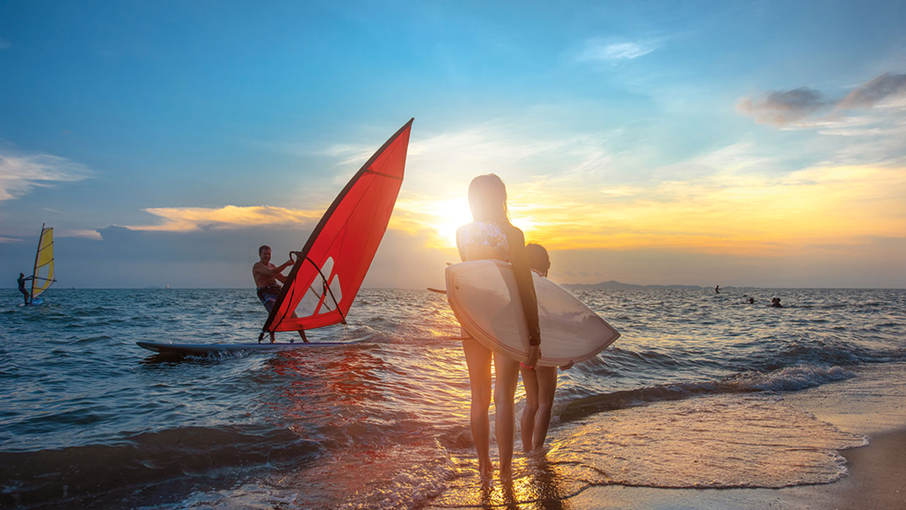 Schüler surfen an der Adriaküste bei Sonnenuntergang