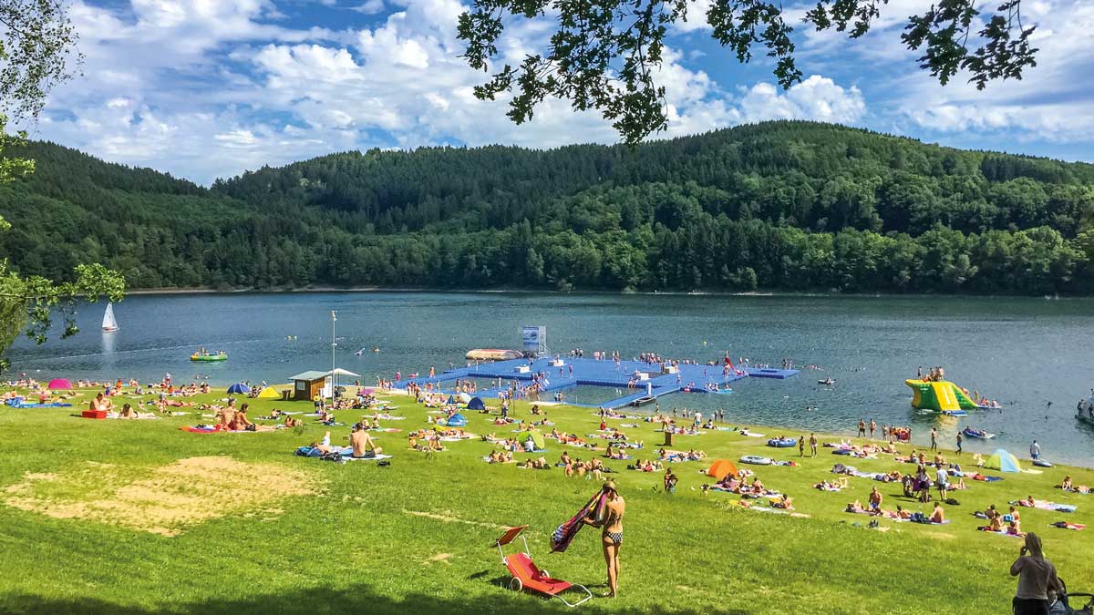 Schüler liegen auf einer Wiese am Biggesee im Sauerland